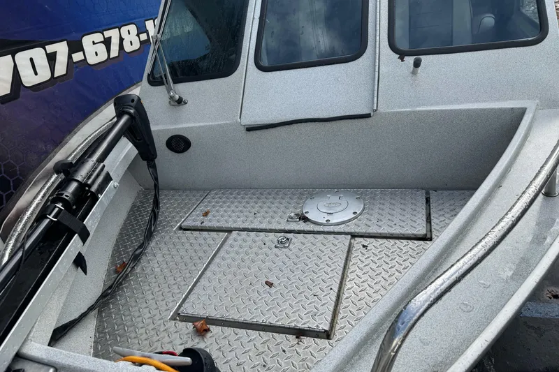 Slide: The Image of 1994 Jetcraft Yukon boat deck with diamond plate flooring and storage hatch. - 4
