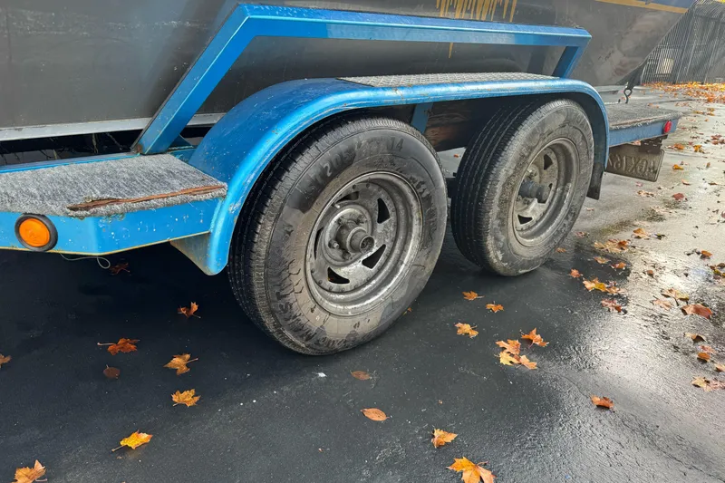 Slide: The Image of Blue trailer with dual wheels, Jetcraft Yukon 1994, on wet pavement with autumn leaves. - 6