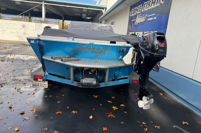 Slide: The Image of 1994 Jetcraft Yukon boat with Mercury outboard motor, parked on wet pavement. - 7
