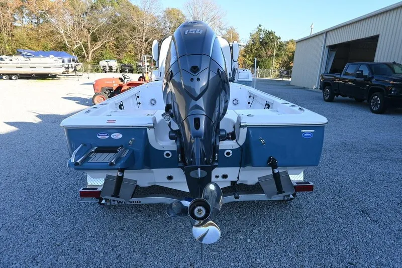 Slide: The Image of 2026 Tidewater 2110 Bay Max boat with outboard motor, parked on gravel. - 4