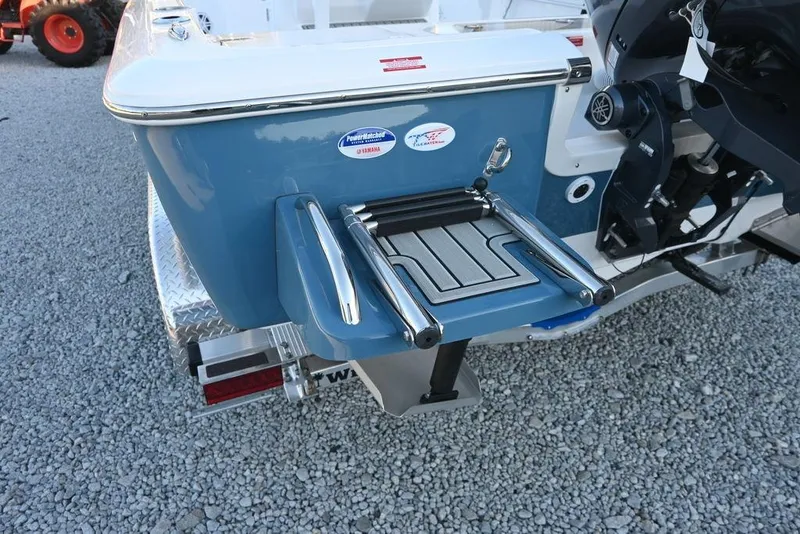 Slide: The Image of 2026 Tidewater 2110 Bay Max boat with swim platform and motor, on gravel surface. - 5