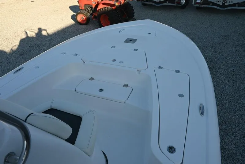 Slide: The Image of 2026 Tidewater 2110 Bay Max boat deck with storage compartments, parked on gravel. - 9