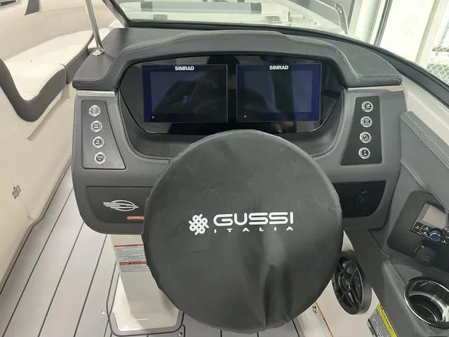 Slide: The Image of 2025 Chaparral 247 SSX boat dashboard with dual Simrad displays and Gussi Italia steering wheel. - 10
