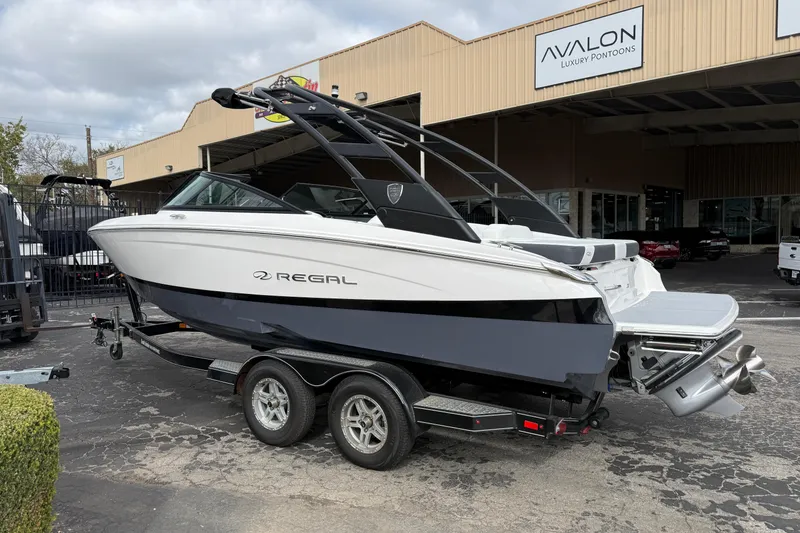 Slide: The Image of 2026 Regal LS2 boat on trailer outside Avalon Luxury Pontoons dealership. - 4