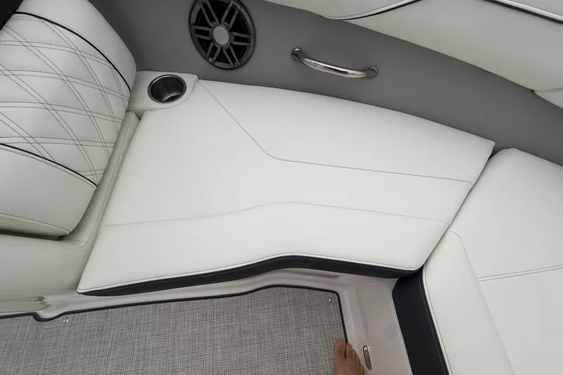 Slide: The Image of 2026 Regal LS2 boat interior with white leather seating, cup holder, and speaker. - 45