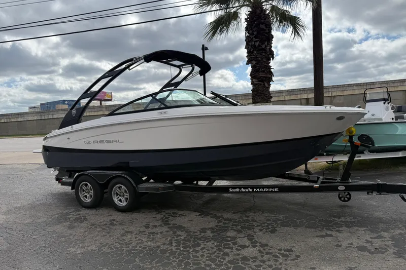 Slide: The Image of 2026 Regal LS2 boat on trailer, parked outdoors under cloudy sky. - 54