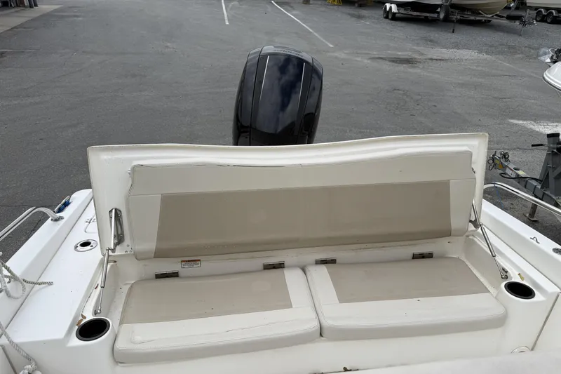 Slide: The Image of 2018 Boston Whaler 180 Dauntless boat interior with cushioned seating and motor view. - 7