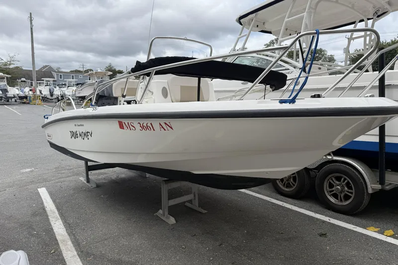 Slide: The Image of 2018 Boston Whaler 180 Dauntless boat on trailer in marina parking lot. - 9