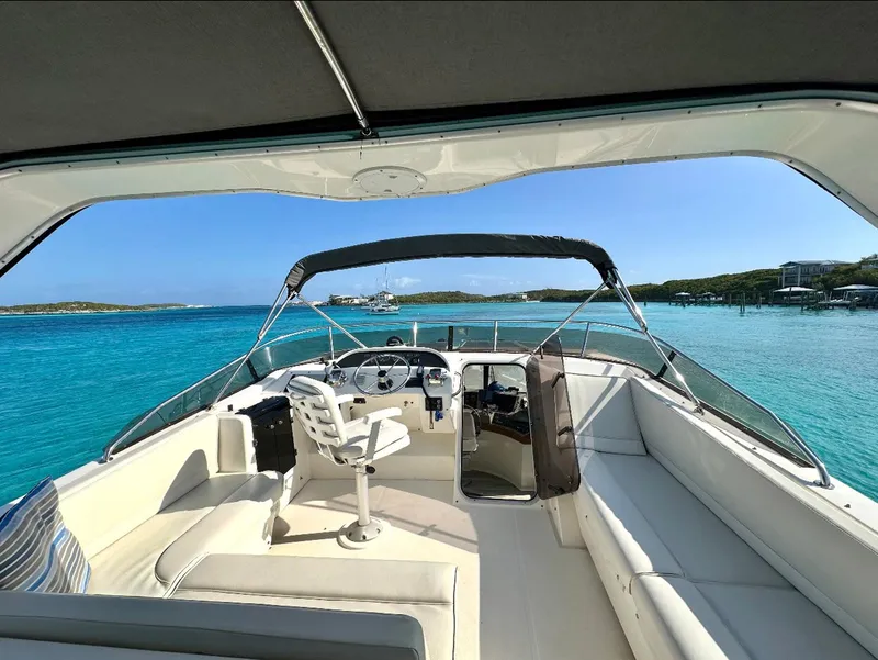 Slide: The Image of 1995 Bayliner 4788 Pilothouse Motoryacht interior with ocean view, featuring helm and seating area. - 22