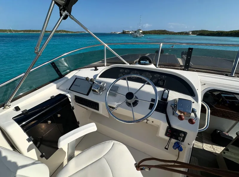 Slide: The Image of 1995 Bayliner 4788 Pilothouse Motoryacht helm with ocean view and clear blue skies. - 4