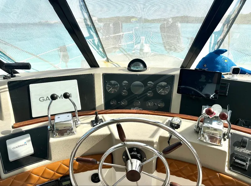 Slide: The Image of 1995 Bayliner 4788 Pilothouse Motoryacht helm with Garmin navigation system and steering wheel. - 5