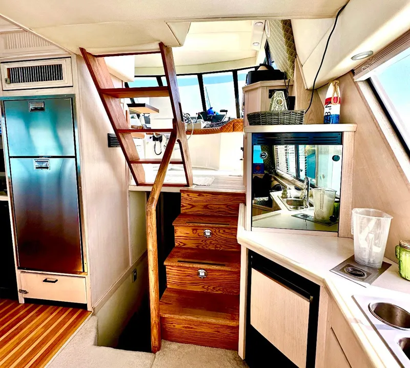 Slide: The Image of Interior of 1995 Bayliner 4788 Pilothouse Motoryacht with wooden stairs and kitchenette. - 7