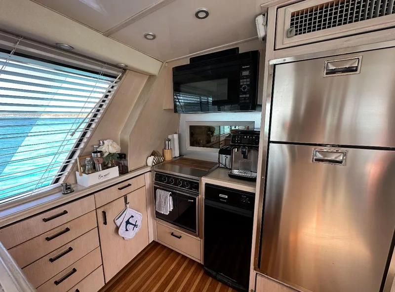 Slide: The Image of 1995 Bayliner 4788 Pilothouse Motoryacht kitchen with modern appliances and wood flooring. - 9