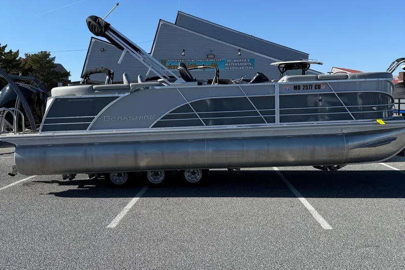 The Image of 2024 Berkshire 23E STS 3.0 pontoon boat parked in a lot, side view. - 1