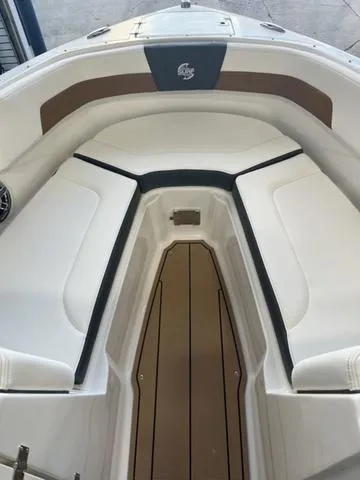 Slide: The Image of 2025 Chaparral 23 Surf boat interior with white and brown seating. - 11
