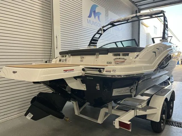 Slide: The Image of 2025 Chaparral 23 Surf boat on trailer in garage, rear view. - 3