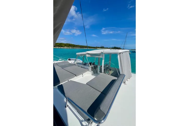 Slide: The Image of 2015 Fountaine Pajot Helia Maestro catamaran with sunbathing area, anchored in turquoise waters. - 18