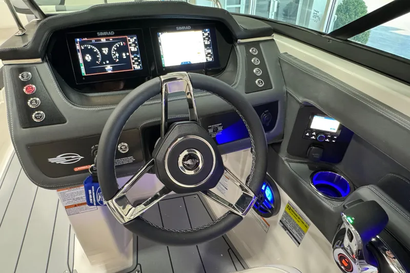 Slide: The Image of 2025 Chaparral 247 SSX boat dashboard with steering wheel and digital displays. - 12