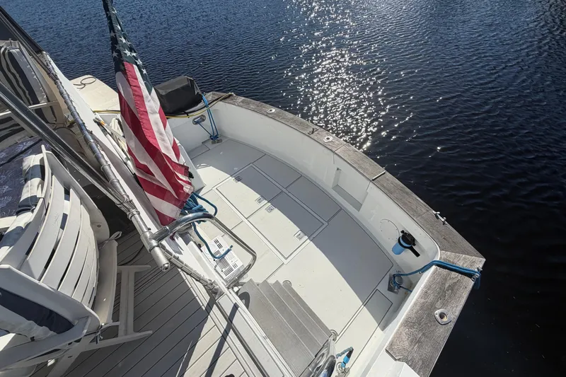 Slide: The Image of 1987 Hi-Star 55 Yacht Fisherman deck with American flag, overlooking sparkling water. - 16