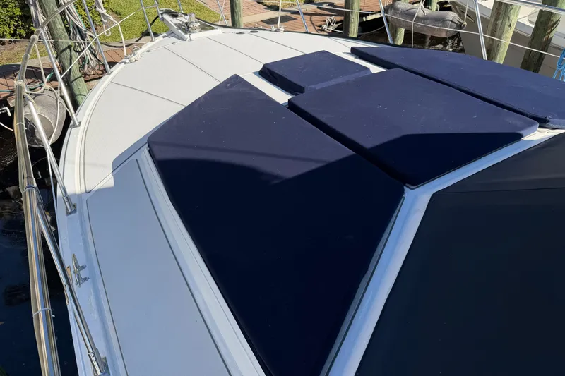 Slide: The Image of 1987 Hi-Star 55 Yacht Fisherman with blue cushions on deck, docked at marina. - 2