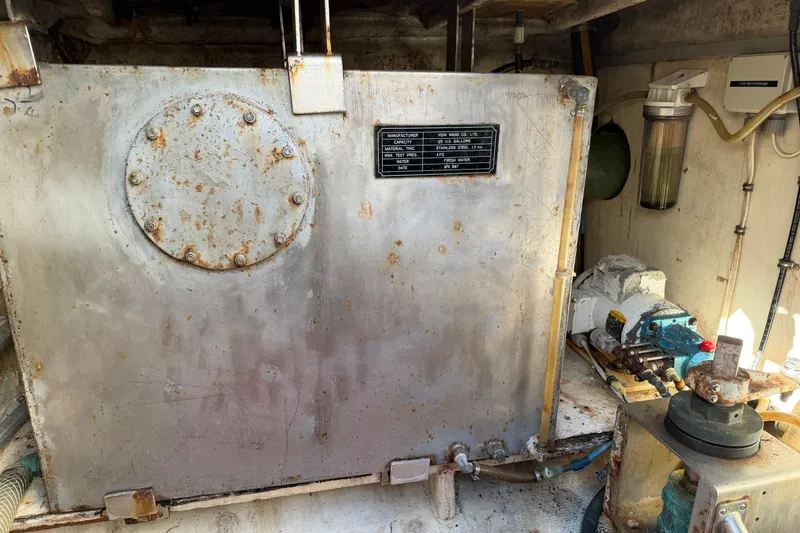 Slide: The Image of Engine room of a 1987 Hi-Star 55 Yacht Fisherman, featuring a metal tank and machinery. - 22