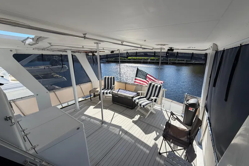 Slide: The Image of 1987 Hi-Star 55 Yacht Fisherman deck with seating, American flag, and waterfront view. - 24