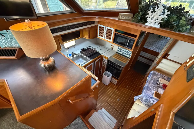 Slide: The Image of 1987 Hi-Star 55 Yacht Fisherman interior with kitchen, dining area, and cozy decor. - 29