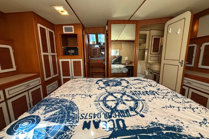 Slide: The Image of Luxurious 1987 Hi-Star 55 Yacht Fisherman cabin with nautical-themed bedding and wooden cabinetry. - 42