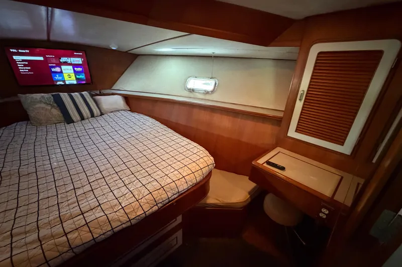 Slide: The Image of 1987 Hi-Star 55 Yacht Fisherman cabin with bed, TV, and wooden interior. - 45