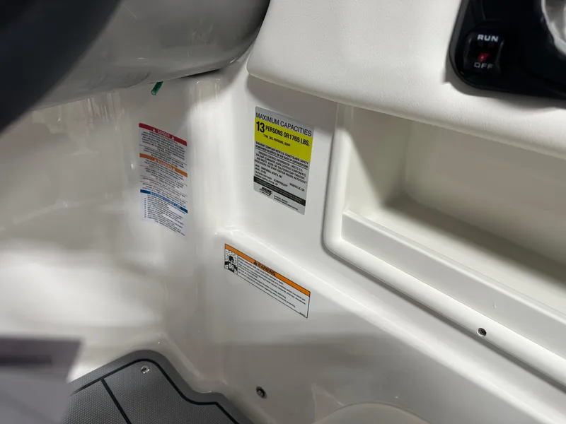 Slide: The Image of 2025 Chaparral 23 SSi boat interior with capacity and safety labels visible. - 17