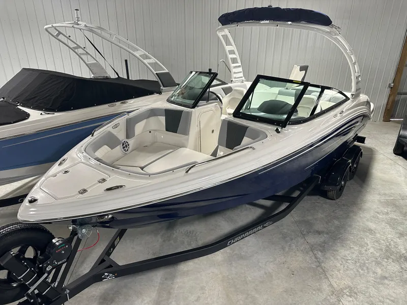 Slide: The Image of 2025 Chaparral 23 SSi boat in showroom, featuring sleek design and modern amenities. - 2