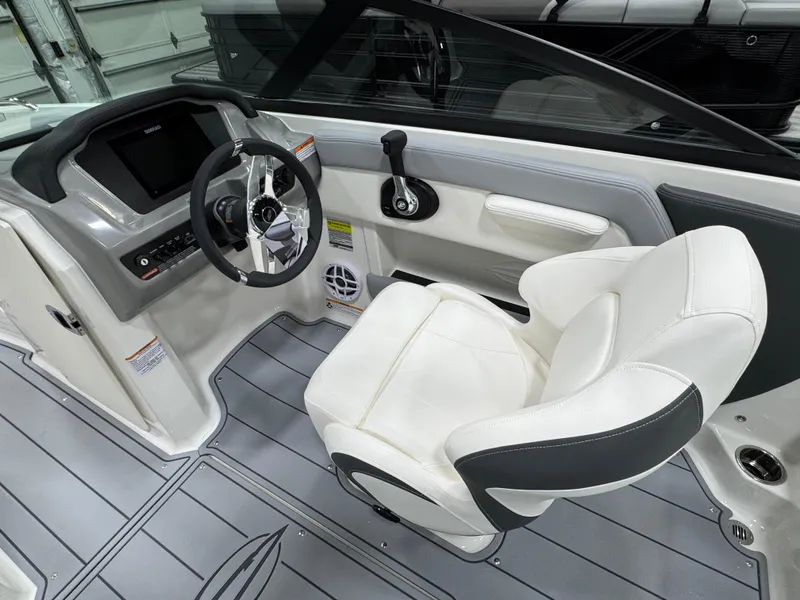 Slide: The Image of 2025 Chaparral 21 SSi boat interior with modern steering and white seating. - 15
