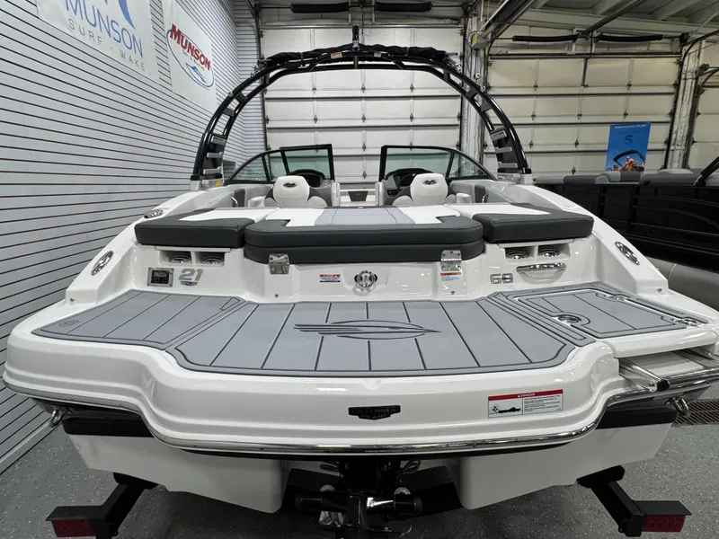 Slide: The Image of 2025 Chaparral 21 SSi boat in showroom, rear view with sleek design and seating. - 9