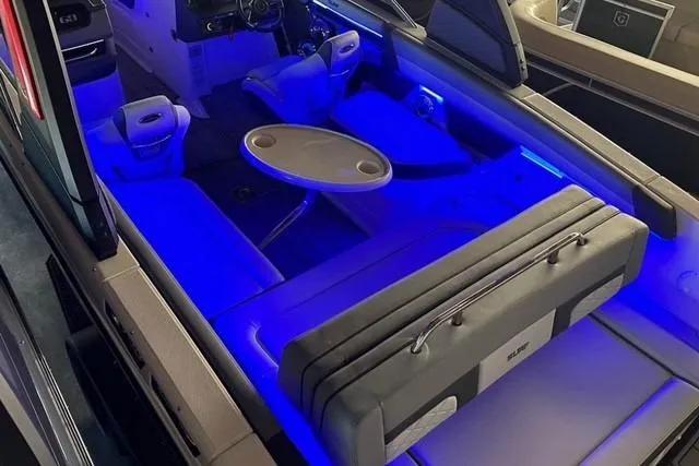 Slide: The Image of 2025 Chaparral 2870 SSX boat interior with blue LED lighting and seating area. - 10