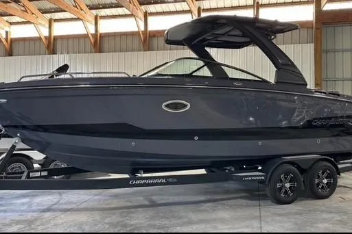 Slide: The Image of 2025 Chaparral 2870 SSX boat in a warehouse, sleek black design on trailer. - 19