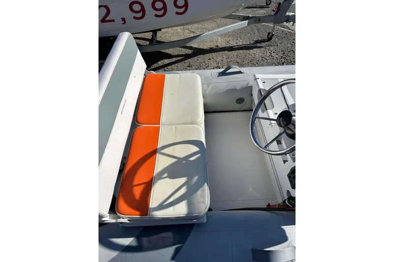 Slide: The Image of 2016 Walker Bay 325 ST boat interior with orange and white seating, steering wheel visible. - 13