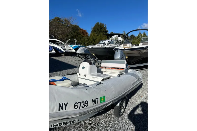 Slide: The Image of 2016 Walker Bay 325 ST inflatable boat in a marina, surrounded by other boats. - 4