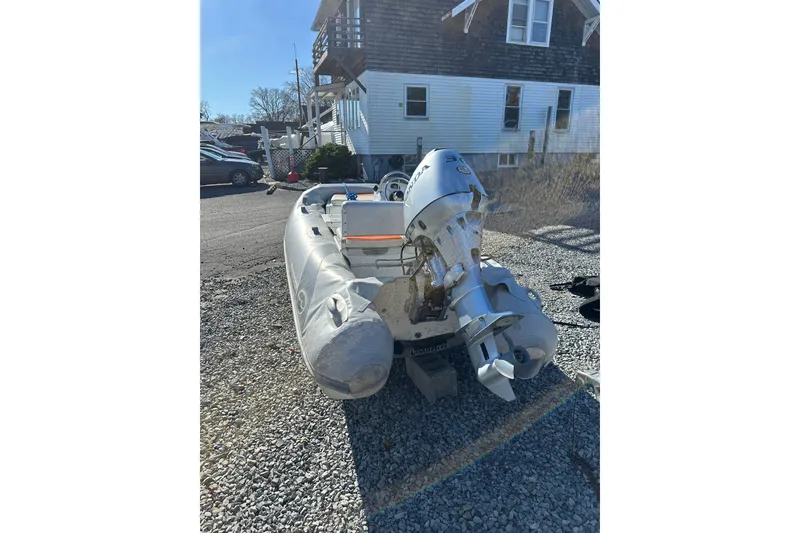 Slide: The Image of 2016 Walker Bay 325 ST inflatable boat with outboard motor on gravel driveway. - 7