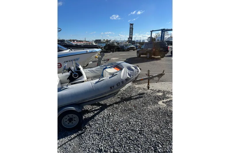Slide: The Image of 2016 Walker Bay 325 ST inflatable boat on trailer in parking lot. - 9