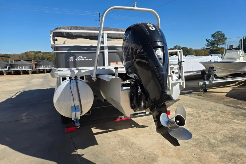 Slide: The Image of 2019 Sun Tracker Fishin' Barge 22 XP3 pontoon boat with outboard motor, parked outdoors. - 3