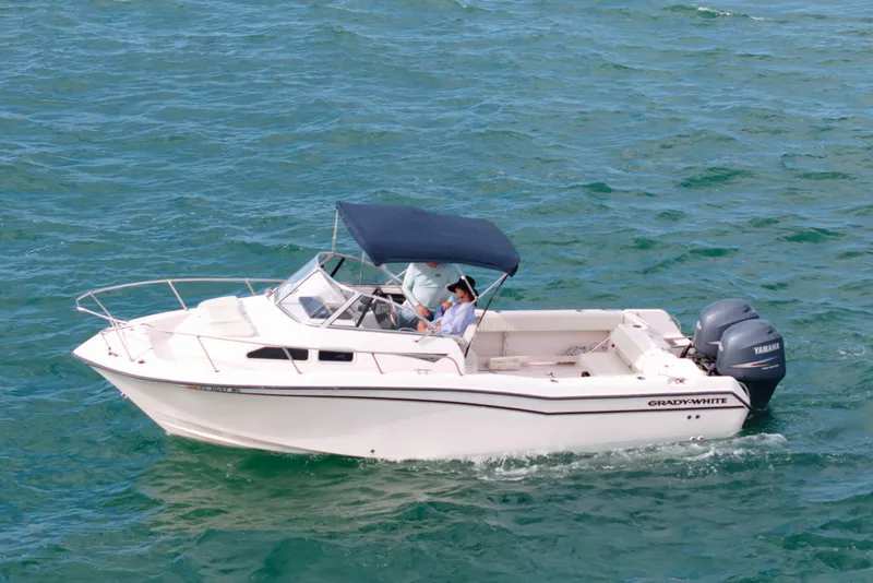 The Image of 2005 Grady-White Journey 258 boat cruising on open water with two passengers. - 0