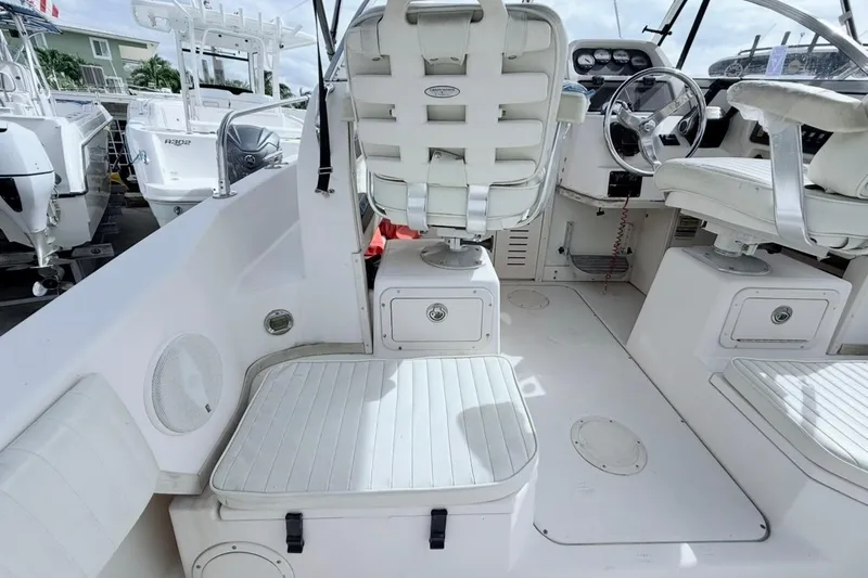 Slide: The Image of 2005 Grady-White Journey 258 boat interior with white seating and steering console. - 11