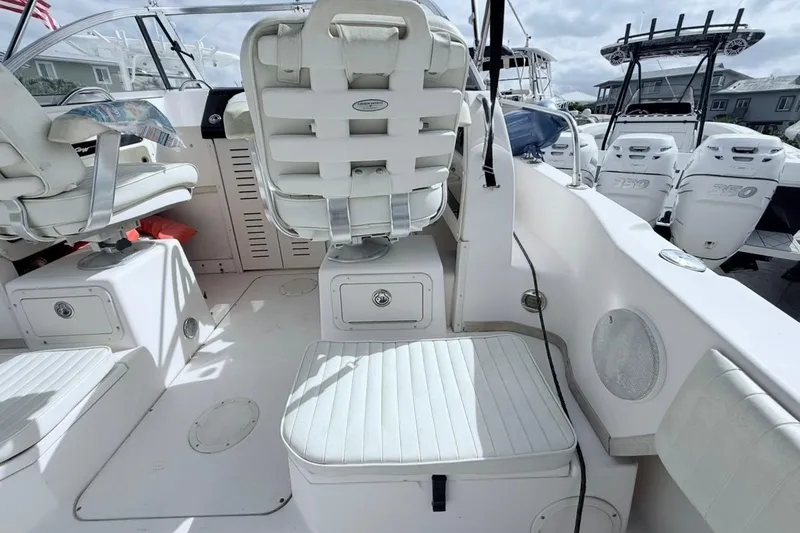 Slide: The Image of 2005 Grady-White Journey 258 boat interior with white seating and control panel. - 12