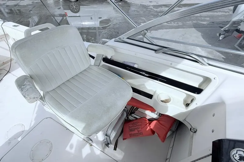 Slide: The Image of Captain's seat on 2005 Grady-White Journey 258 boat, featuring helm controls and safety equipment. - 20