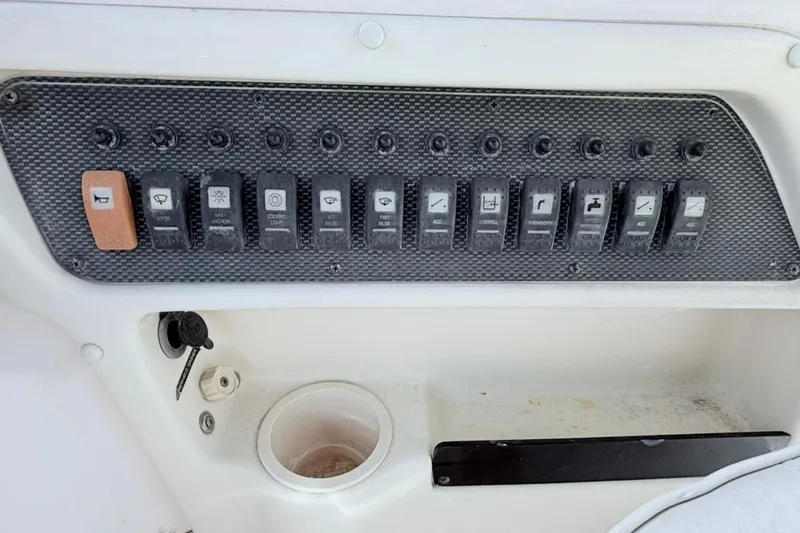 Slide: The Image of Control panel of a 2005 Grady-White Journey 258 boat with multiple switches. - 21