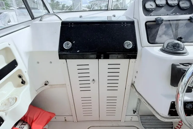 Slide: The Image of 2005 Grady-White Journey 258 boat dashboard with steering wheel and control panel. - 24