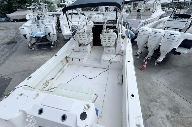 Slide: The Image of 2005 Grady-White Journey 258 boat with dual seats and outboard motors in a marina. - 47