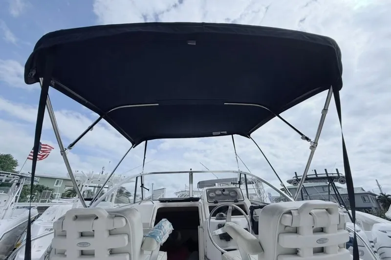 Slide: The Image of 2005 Grady-White Journey 258 boat interior with canopy and steering wheel. - 48