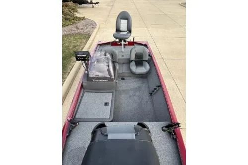Slide: The Image of 2020 Tracker Pro 160 boat interior with seating and control panel, parked on pavement. - 4