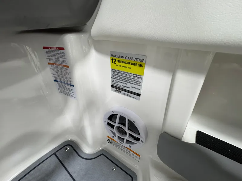 Slide: The Image of 2025 Chaparral 21 SSi boat interior showing capacity label and speaker. - 18